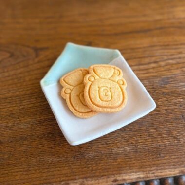 頭の上にコーヒーカップをのせたくまちゃんクッキーがお皿にのせられている