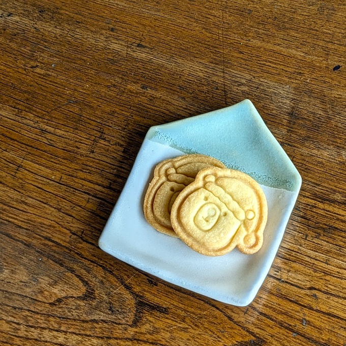 お皿にのせられたサンタ帽子をかぶったくまのクッキー