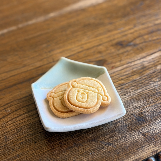 サンタ帽子をかぶったくまの顔の形をしたクッキー2枚がお皿にのせられている
