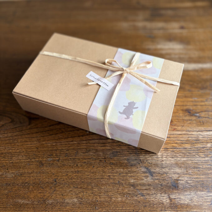 くまのイラストが描かれた帯とリボンでラッピングされたクラフトボックス