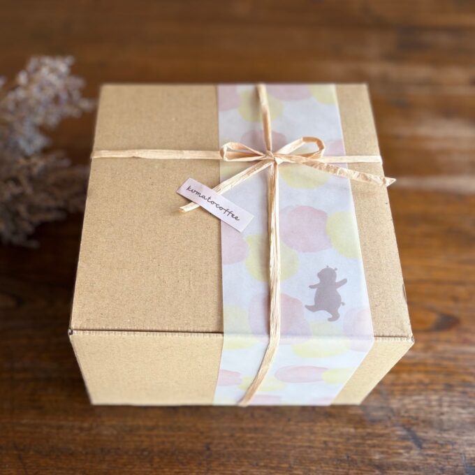 くまのイラストが描かれた帯とリボンでラッピングされたクラフトボックス