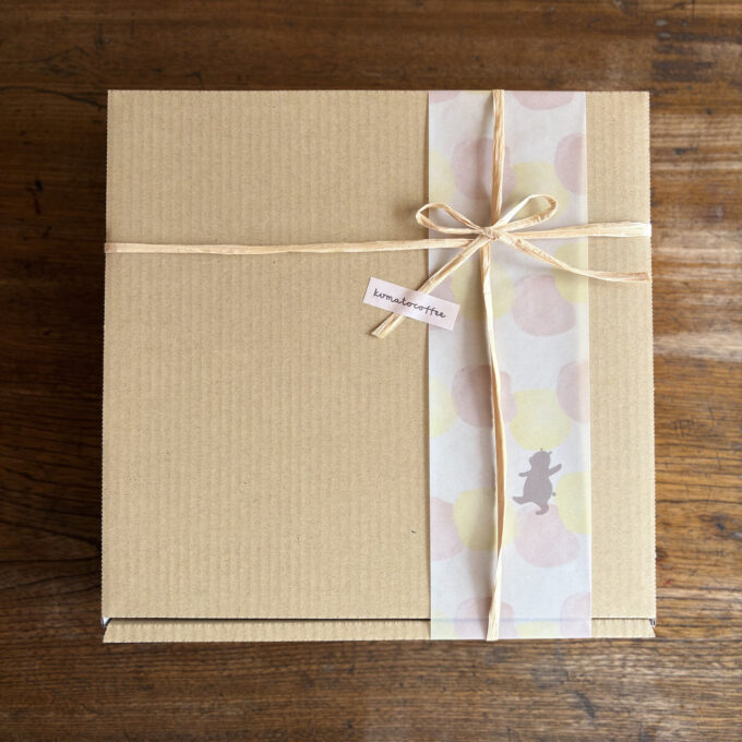 くまのイラストが描かれた帯とリボンでラッピングされたクラフトボックス